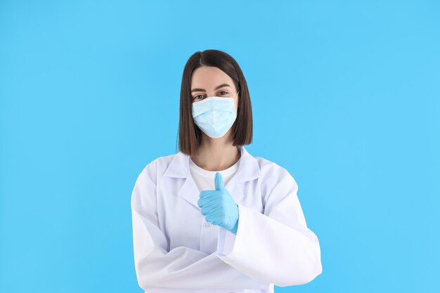 Femme médecin en masque et gants sur fond bleu