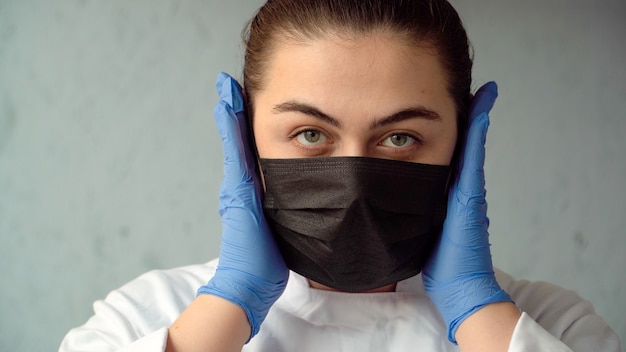 Femme médecin met un masque médical