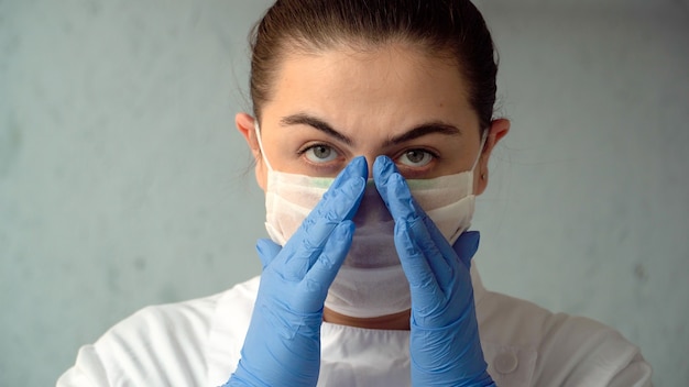 Femme médecin met un masque médical