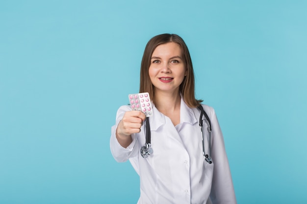 Femme médecin montrant des pilules roses