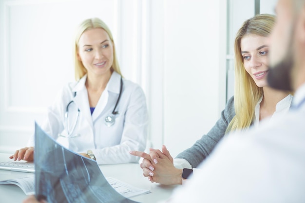 Femme médecin montre la radiographie pulmonaire du patient