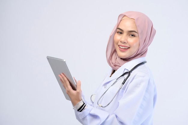 Une femme médecin musulmane avec hijab sur fond blanc studio