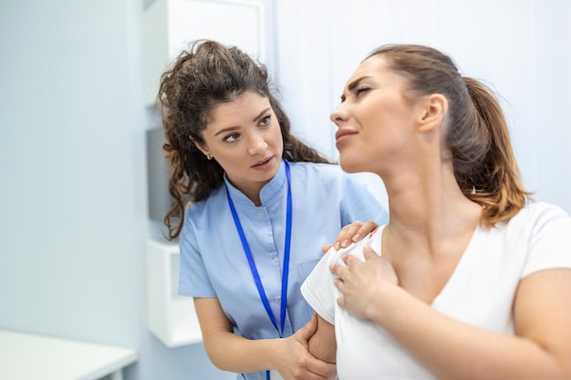 Femme médecin ostéopathe en uniforme médical fixant les articulations des épaules et du dos des patientes dans une clinique de thérapie manuelle lors de la visite Ostéopathe professionnel pendant le travail avec le concept du patient