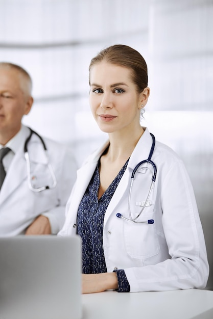 Femme médecin participant à une conférence médicale ou rencontrant ses collègues masculins. Notion de médecine.