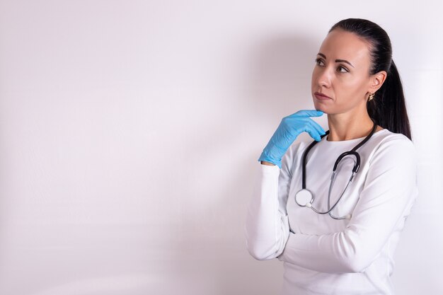 Femme médecin pensant à un fond blanc