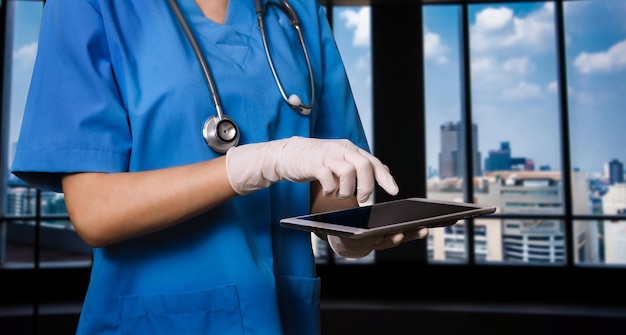 Photo femme médecin portant des gommages à l'hôpital à l'aide d'une tablette