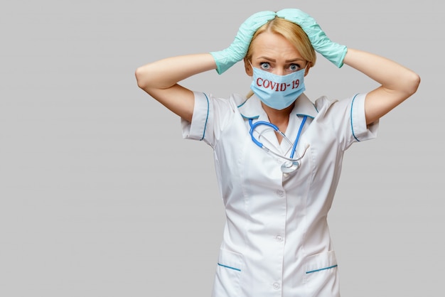 Femme médecin portant un masque de protection et des gants en latex maux de tête et stress