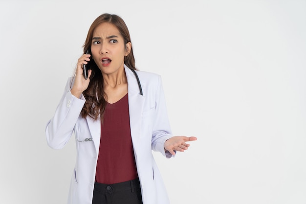 Une femme médecin portant un uniforme blanc est choquée lors d'un appel téléphonique avec de l'espace