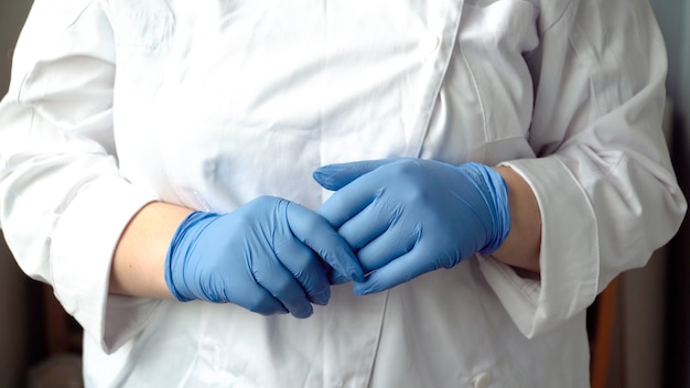 La femme médecin porte des gants bleus