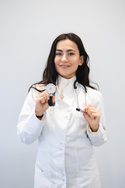 Femme médecin positive avec stéthoscope en clinique