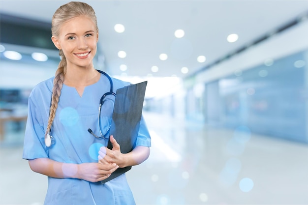 Femme médecin avec presse-papiers souriant à la caméra