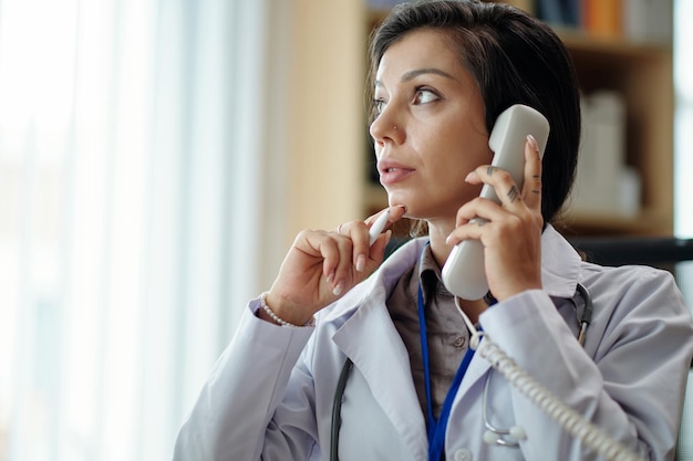 Femme médecin répondant à un appel téléphonique
