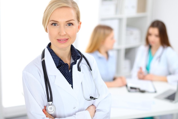 Femme médecin souriant sur le fond avec le patient et son médecin à l'hôpital