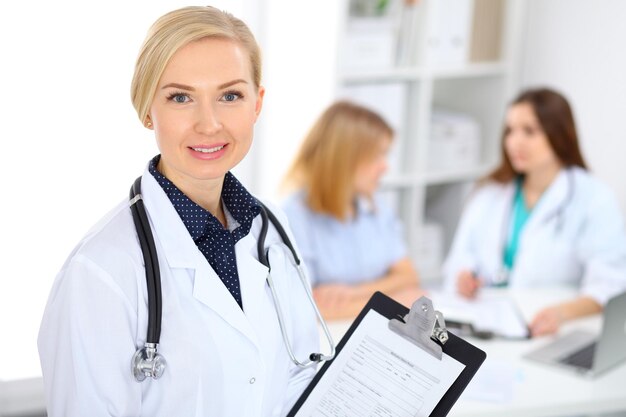 Femme médecin souriant sur le fond avec le patient et son médecin à l'hôpital.