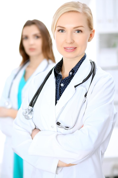 Femme médecin souriant sur le fond avec le patient.