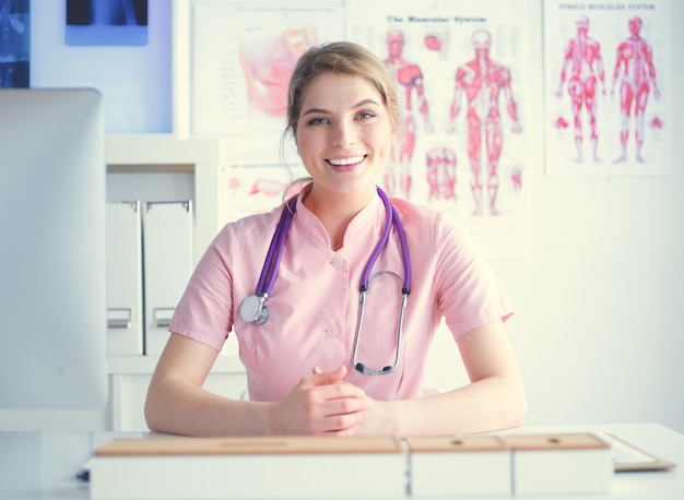 Femme médecin souriante avec un dossier en uniforme debout