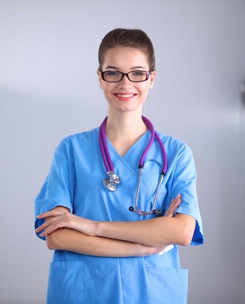 Femme médecin souriante avec un dossier en uniforme à l'hôpital