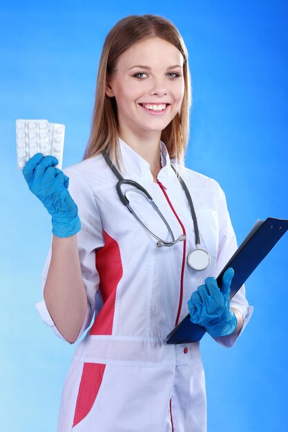 Femme médecin souriante avec un dossier en uniforme à l'hôpital