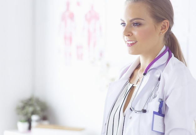 Femme médecin souriante avec un stéthoscope médical en uniforme debout