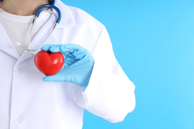 Photo femme médecin stagiaire avec coeur sur fond bleu