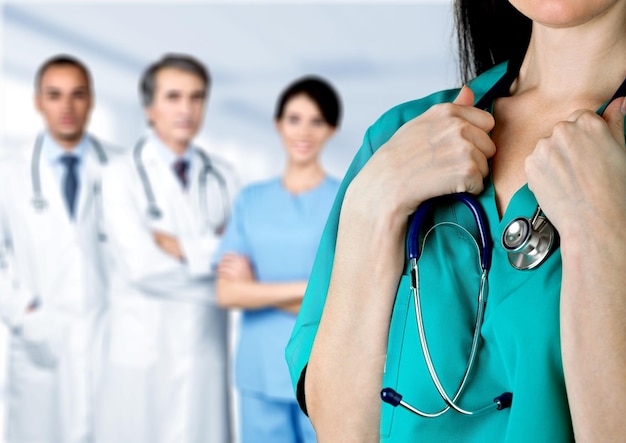 Femme médecin avec stéthoscope et équipe sur fond