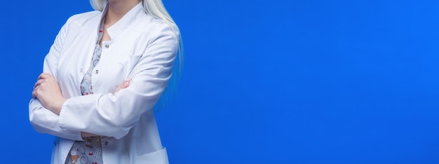 Femme médecin avec stéthoscope en fond bleu.