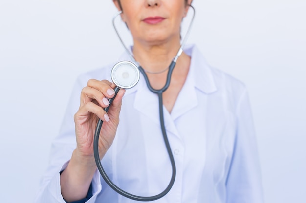 Femme médecin avec stéthoscope, gros plan sur mur blanc