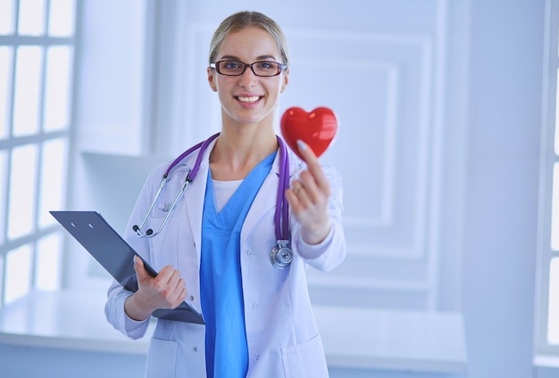 Femme médecin avec stéthoscope tenant coeur.