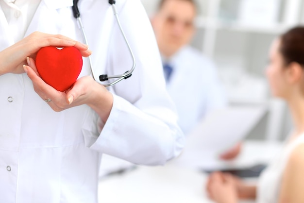 Femme médecin avec stéthoscope tenant coeur