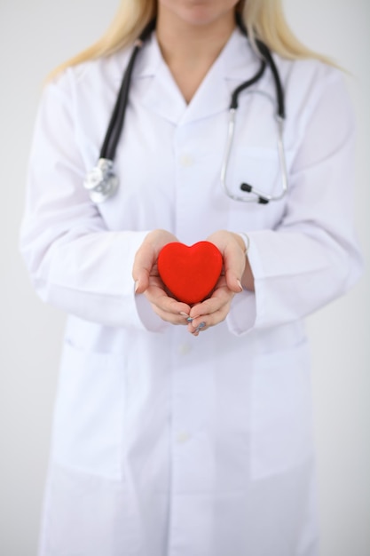 Femme médecin avec stéthoscope tenant coeur