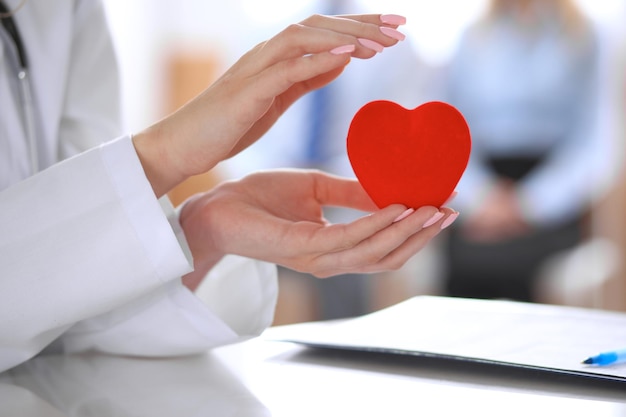 Femme médecin avec stéthoscope tenant coeur