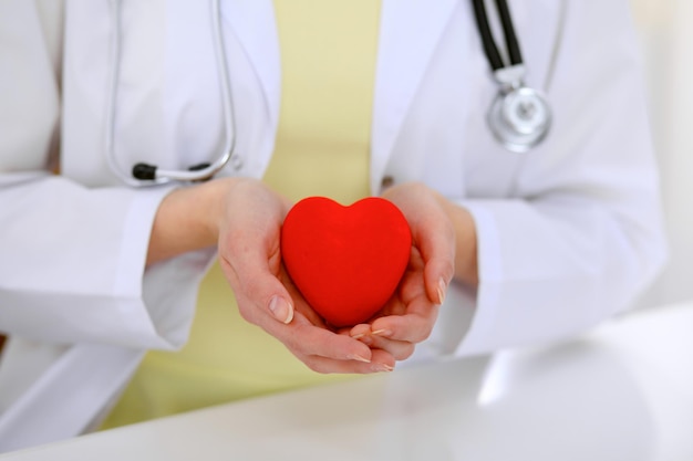 Femme médecin avec stéthoscope tenant coeur