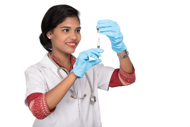 Une femme médecin avec un stéthoscope tient une injection ou une seringue.