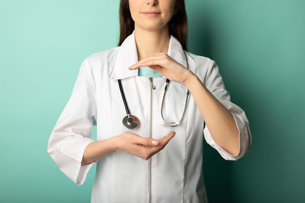 Femme médecin avec un stéthoscope tient quelque chose dans les mains Concept d'aide et de soins