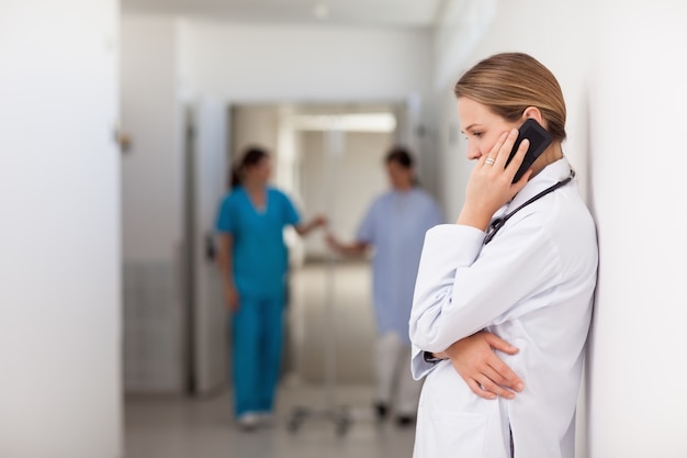 Femme médecin téléphonant dans le couloir