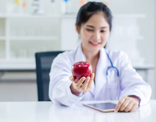 Femme médecin tenant une pomme rouge sur place