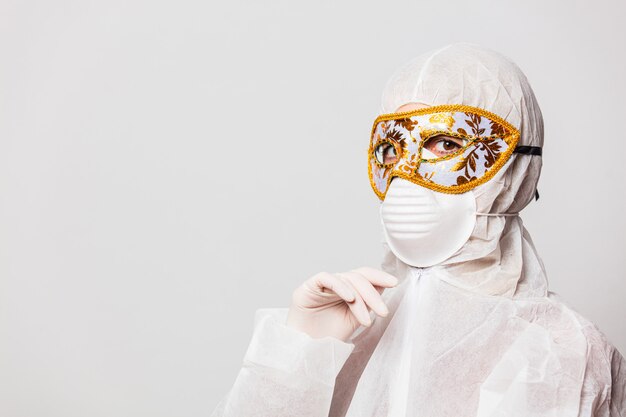 femme médecin en tenue de protection et lunettes avec masque de carnaval vénitien