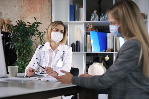 Femme médecin thérapeute d'âge moyen en consultation avec un patient au bureau