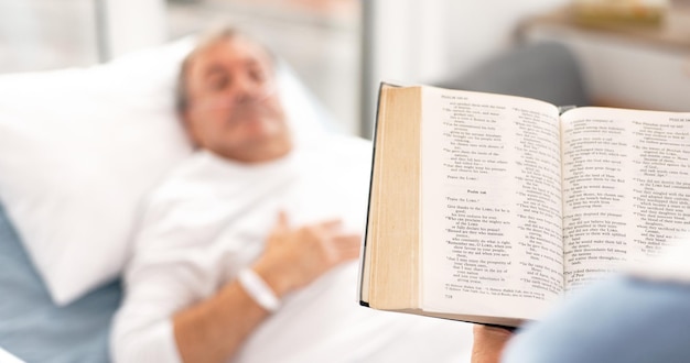 Une femme médicale lisant la Bible à son mari lors d'une visite et un couple à l'hôpital soins de santé retraite ou religion avec une femme et un homme âgé patient dans une clinique pour la foi en dieu