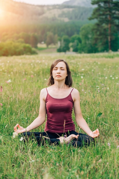 Femme méditant et relaxante dans la nature en été