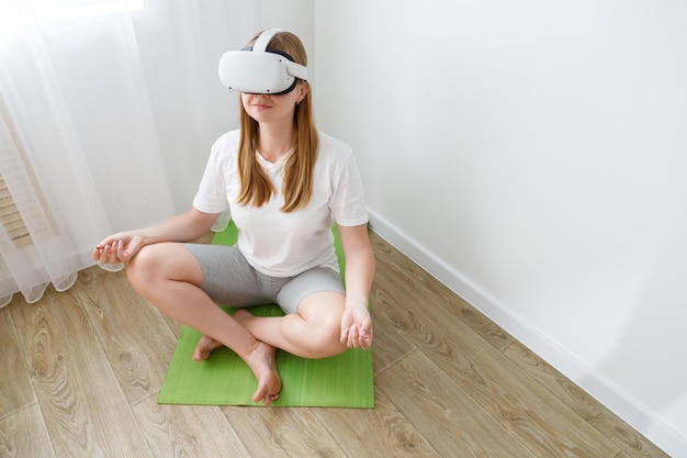 Une femme médite sur le tapis de la maison