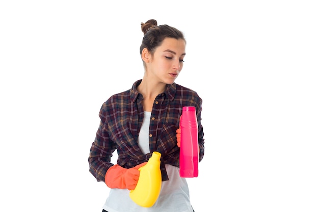 Femme de ménage de beauté avec des nettoyants isolé sur un mur blanc