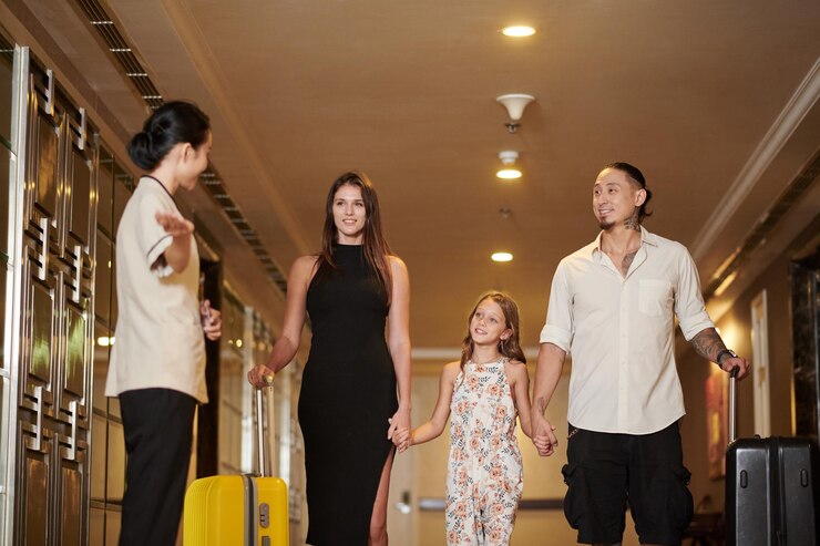 La femme de ménage de l'hôtel montre à la famille le chemin de leur chambre.