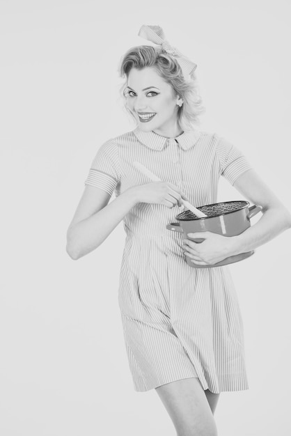 Femme de ménage avec ménage d'ustensiles de cuisine