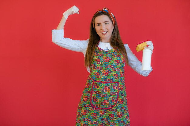 Femme de ménage en uniforme avec une éponge de pulvérisation propre ou une femme heureuse nettoyant avec une bouteille de savon