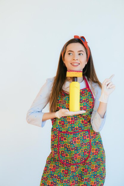 Femme de ménage en uniforme avec une éponge de pulvérisation propre ou une femme heureuse qui nettoie