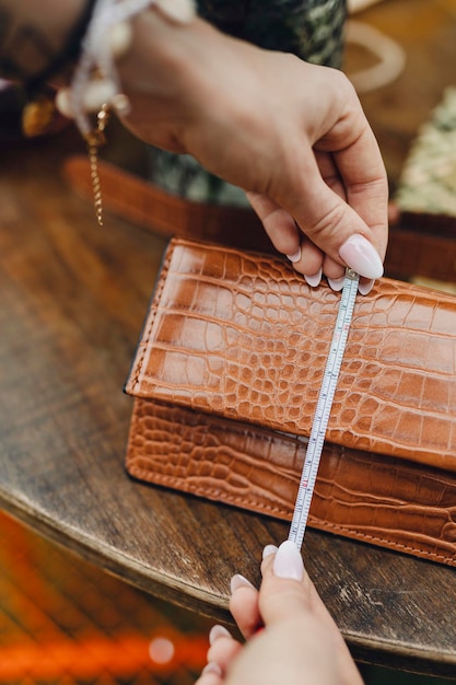 Femme mesurant un portefeuille en cuir