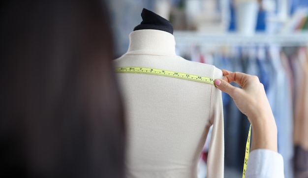 Photo une femme mesure la largeur avec un ruban adhésif sur un mannequin