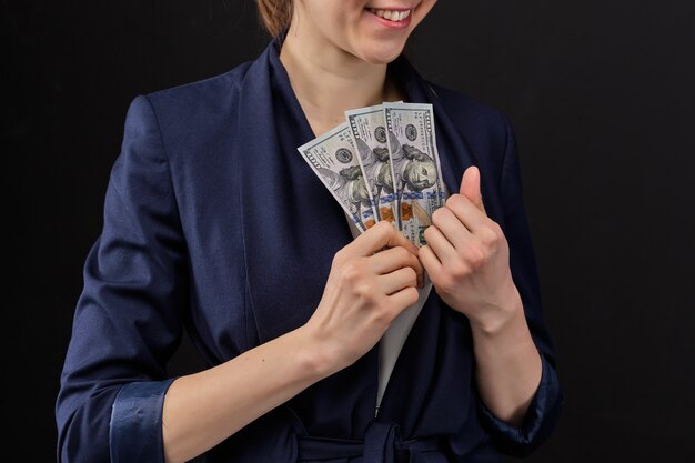 femme met de l'argent dans une veste. Concept de pot-de-vin.