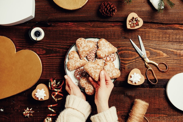 Femme met des biscuits dans une boîte avec des cadeaux